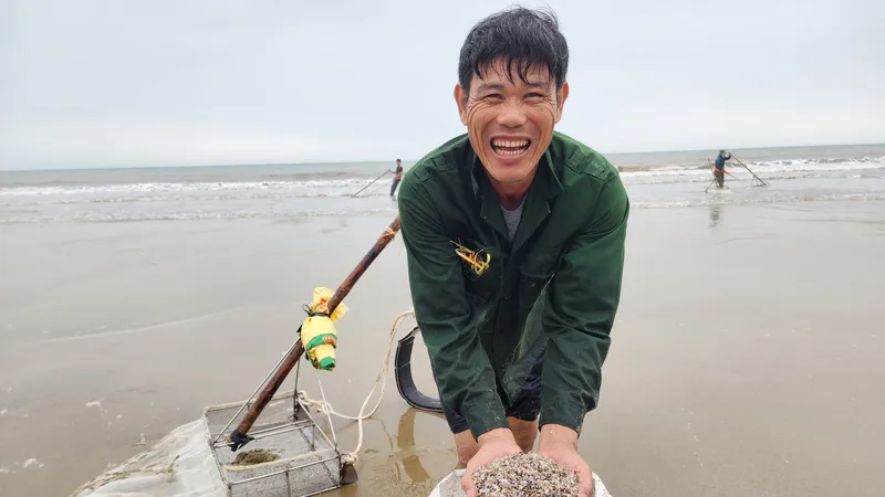 Người dân phấn khởi cào được nhiều ốc tép biển