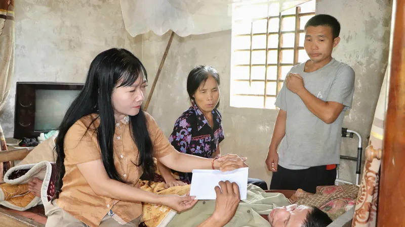 Bà Phan Hồng Yến, Chủ tịch UBND xã Vũ Quang trao 16 triệu đồng của bạn đọc Báo SGGP hỗ trợ gia đình ông Phạm Văn Hiển