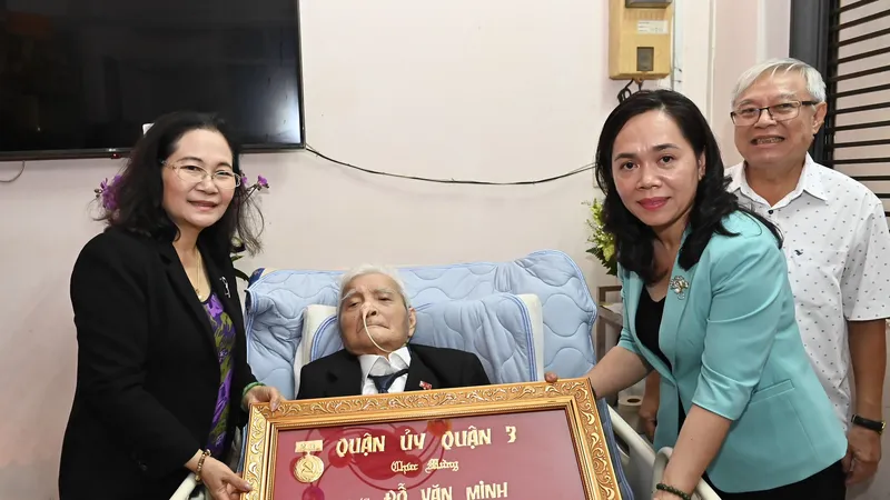 Phó Bí thư Thành ủy Nguyễn Thị Lệ chúc mừng đồng chí Đỗ Văn Minh nhận Huy hiệu Đảng. Ảnh: VIỆT DŨNG