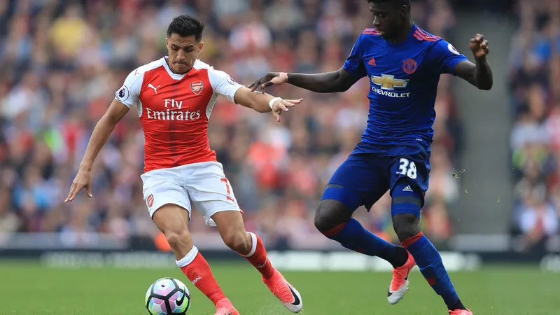  Alexis Sanchez (trái, Arsenal) tranh bóng với Axel Tuanzebe (Man.United).