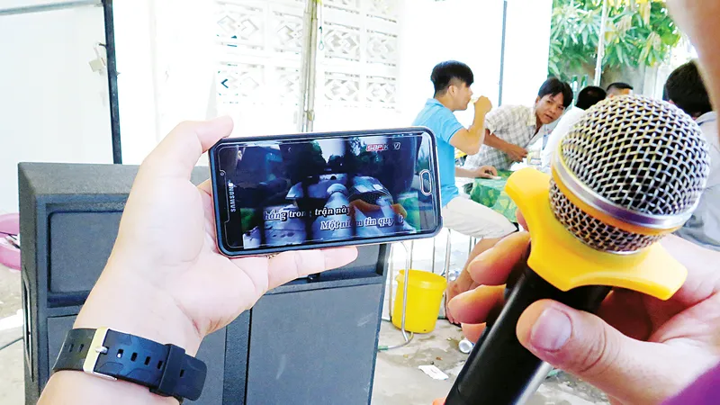 Một đám tiệc, chỉ cần dàn loa, micro kết nối phần mềm karaoke trên điện thoại di động, là đủ hành hạ làng xóm . Ảnh: DŨNG PHƯƠNG