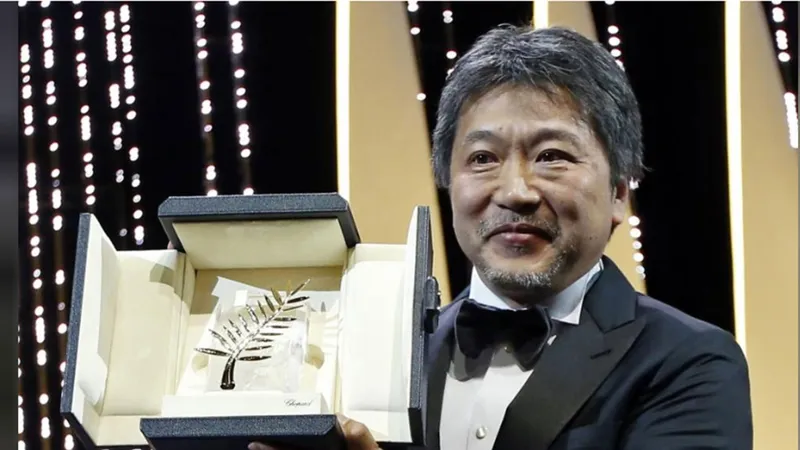 Đạo diễn Hirokazu Kore-eda và Cành cọ vàng danh giá. Ảnh: REUTERS