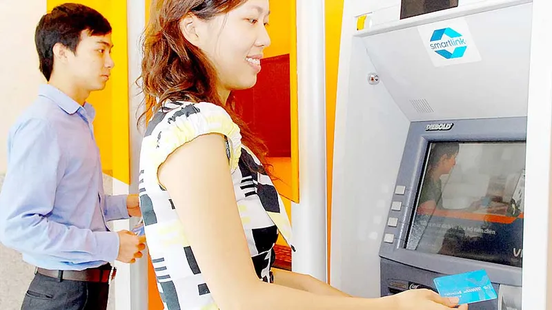 Khách hàng sử dụng thẻ ATM ngân hàng Ảnh: THÀNH TRÍ