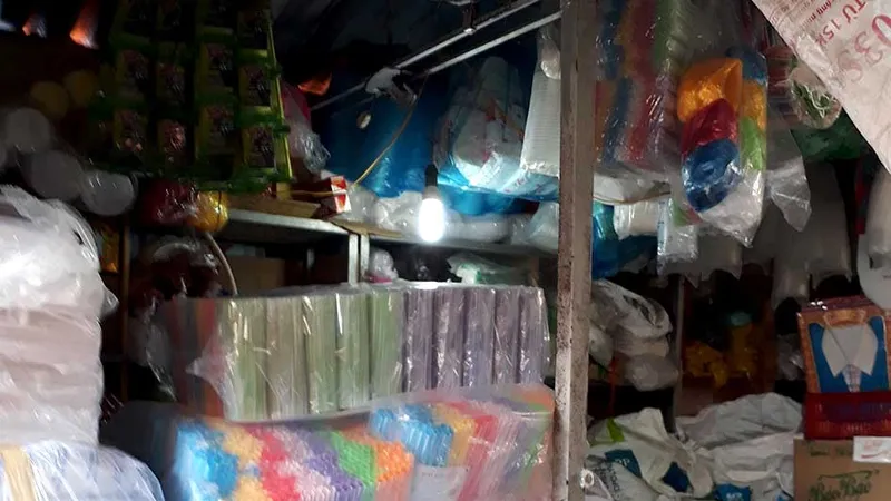 Quầy kinh doanh đồ nhựa chất chồng hàng hóa sát với đèn chiếu sáng, không đảm bảo an toàn phòng cháy 