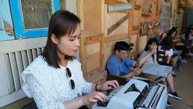 Du khách trải nghiệm máy đánh chữ kiểu cũ trong quán cà phê du lịch cộng đồng tại Trà Vinh. Ảnh: VIỆT DŨNG 
