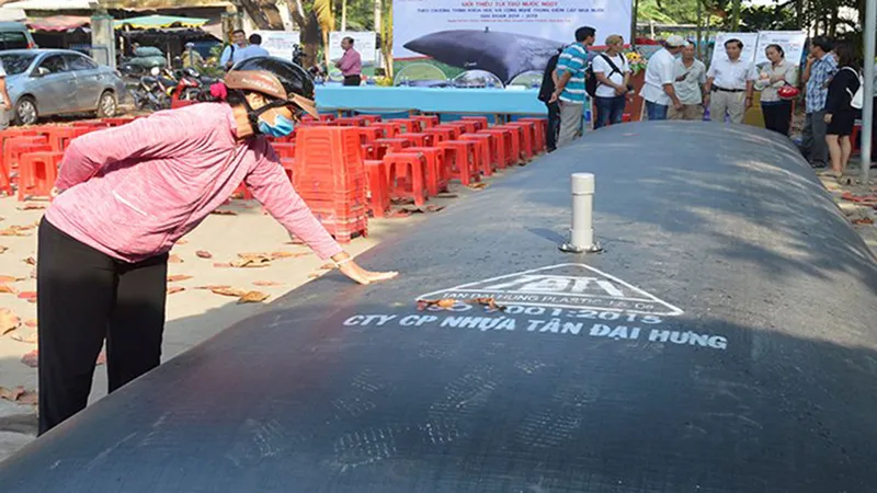 Người dân tham quan túi chứa nước ngọt do các doanh nghiệp giới thiệu để ứng phó với xâm nhập mặn. Ảnh: HỮU HIỆP