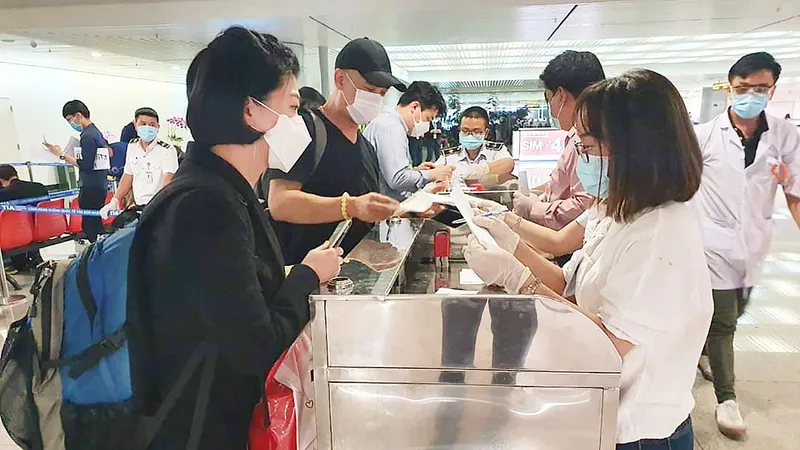 Khách từ Hàn Quốc thực hiện tờ khai y tế tại sân bay Tân Sơn Nhất rạng sáng 24-2. Ảnh: THÀNH SƠN