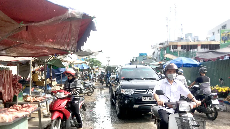 Cảnh nhộn nhịp mua bán, đi lại giữa công trường đang thi công nâng cấp mở rộng đường