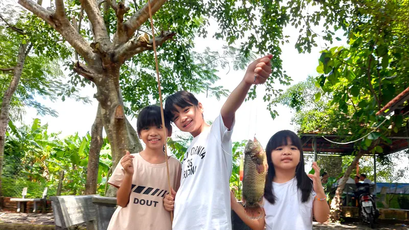 Trẻ em vui chơi ở quê bên vườn tược, cây trái. Ảnh: HOÀNG HÙNG