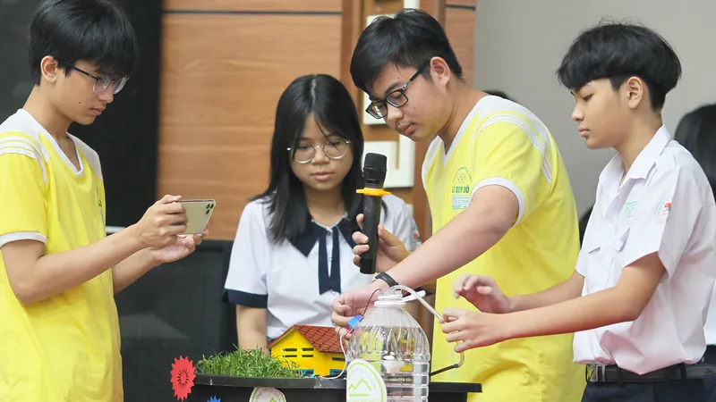 Các em giới thiệu hệ thống tưới tự động bằng cảm ứng đo độ ẩm của đất. Ảnh: HOÀNG HÙNG