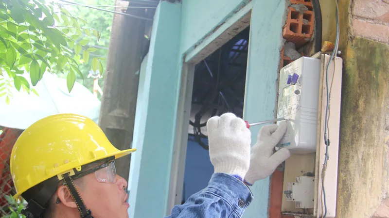 Nhân viên EVNHCMC gắn điện kế cho khách hàng