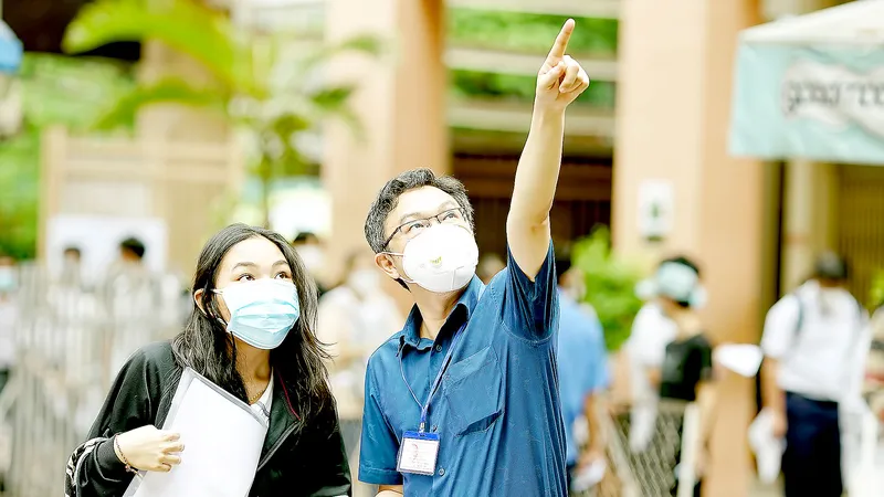 Giám thị hướng dẫn thí sinh tại điểm thi Trường THCS Lý Phong, quận 5, TPHCM. Ảnh: HOÀNG HÙNG