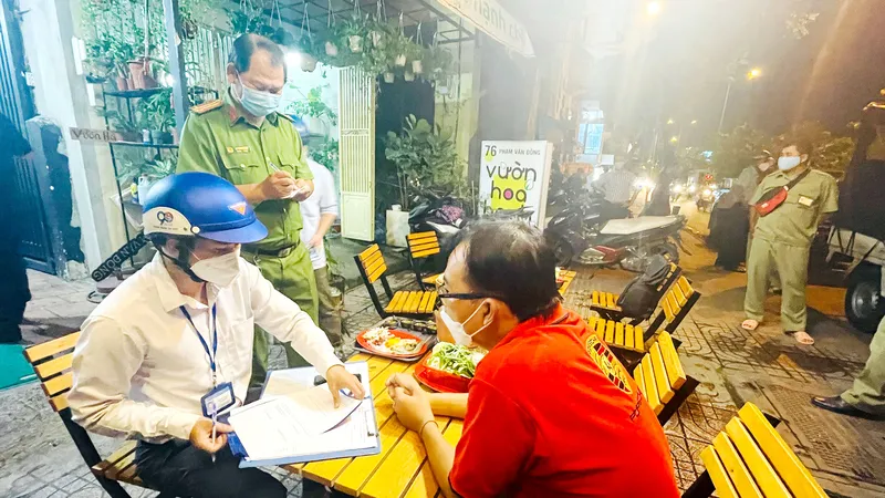 Đoàn kiểm tra phường 3 (quận Gò Vấp) lập biên bản một chủ quán bán rượu bia cho thực khách vào đêm 2-11. Ảnh: VĂN MINH