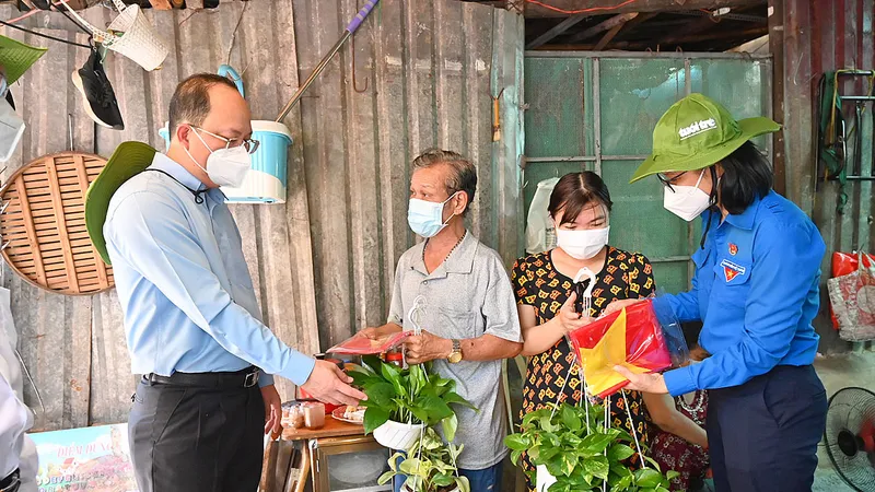 Các bạn đoàn viên, thanh niên tặng cờ Tổ quốc, cây xanh đến người dân 