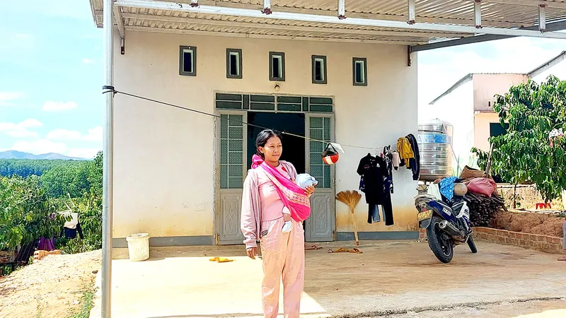 Chị Y Xuyên (xã Đắk Long, huyện Đắk Hà) bên căn nhà ở khu tái định cư