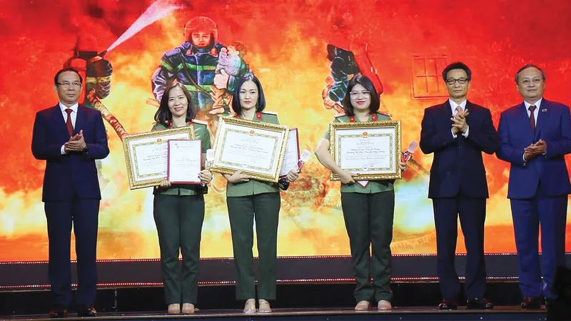 Bí thư Thành ủy TPHCM Nguyễn Văn Nên, Phó Thủ tướng Chính phủ Vũ Đức Đam và Tổng Giám đốc Đài Tiếng nói Việt Nam Đỗ Tiến Sỹ trao giải đặc biệt cho các tác giả tác phẩm Giữa lằn ranh sinh tử. Ảnh: DŨNG PHƯƠNG
