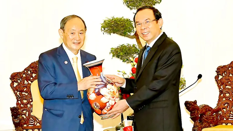 Bí thư Thành ủy TPHCM Nguyễn Văn Nên tặng quà lưu niệm Nguyên Thủ tướng Nhật Bản Suga Yoshihide. Ảnh: VIỆT DŨNG