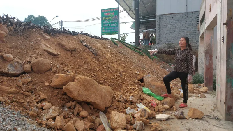 Bà Trần Thị Thanh (thôn Tân Tiến, Phú Lộc, Can Lộc, Hà Tĩnh) bên đường cao hơn nhà. Ảnh: DƯƠNG QUANG
