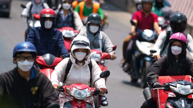 Người dân TPHCM mặc áo khoác khi ra đường vào ban ngày để tránh nắng nóng gay gắt. Ảnh: HOÀNG HÙNG