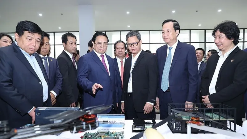 Thủ tướng Phạm Minh Chính tham quan trưng bày các sản phẩm nghiên cứu, chế tạo của Đại học Quốc gia Hà Nội cơ sở Hòa Lạc. Ảnh: TTXVN 