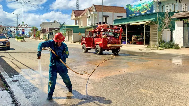 Thành viên Đội PCCC và CHCN tự quản thị trấn Lạc Dương xịt rửa đường ở những khu vực vừa xảy ra sạt lở, bùn đất tràn xuống đường giao thông