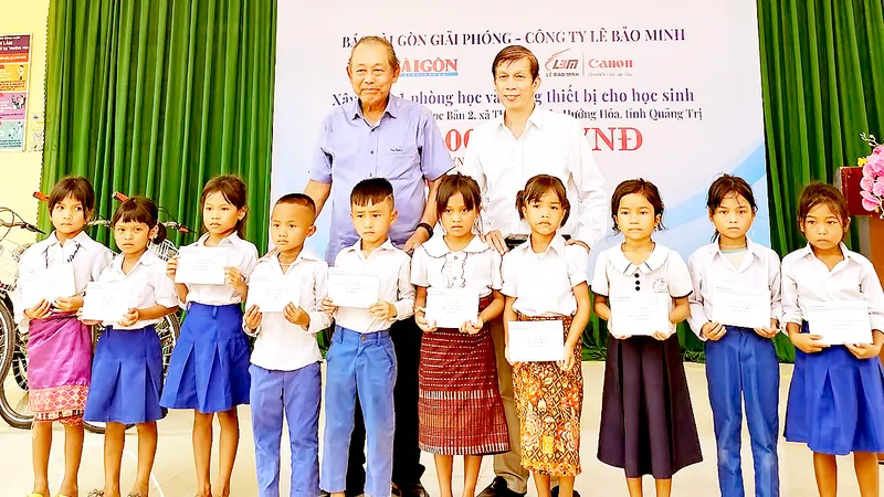 Nguyên Phó Thủ tướng Thường trực Trương Hòa Bình và Phó Tổng biên tập Báo SGGP Nguyễn Khắc Văn trao học bổng Báo SGGP tặng học sinh nghèo vượt khó ở Trường Tiểu học Thuận, huyện Hướng Hóa, tỉnh Quảng Trị