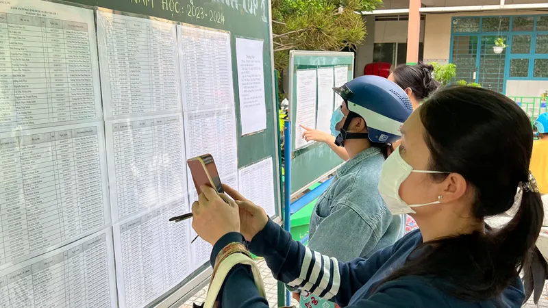 Phụ huynh xem danh sách học sinh lớp 1 tại Trường Tiểu học Phan Đăng Lưu (quận 8, TPHCM) sáng 1-8. Ảnh: CAO THĂNG