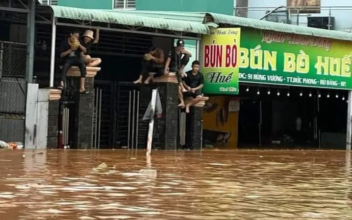 Cơn mưa lớn kéo dài tối ngày 27-7 làm nước dâng khiến người dân leo lên cao chờ lực lượng chức năng đến hỗ trợ