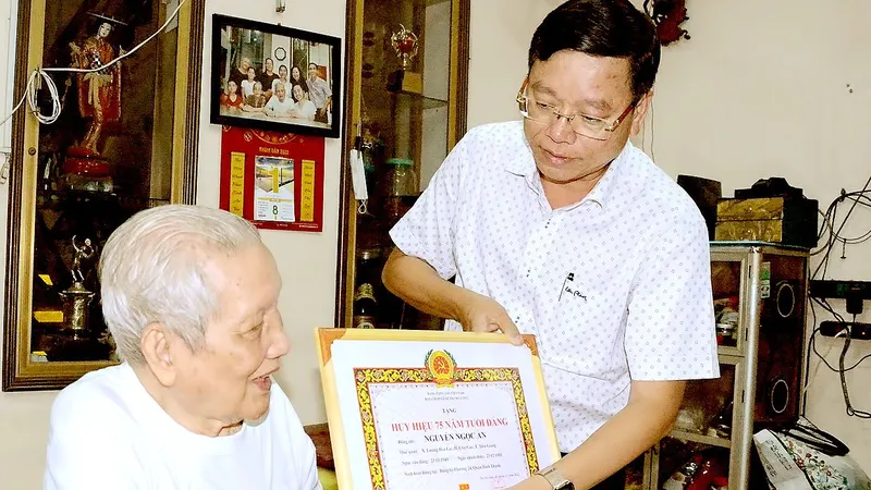 Bí thư Quận ủy quận Bình Thạnh Vũ Ngọc Tuất trao Huy hiệu 75 năm tuổi Đảng tới đồng chí Nguyễn Ngọc Ẩn, năm 2022. Ảnh: HOÀNG ANH