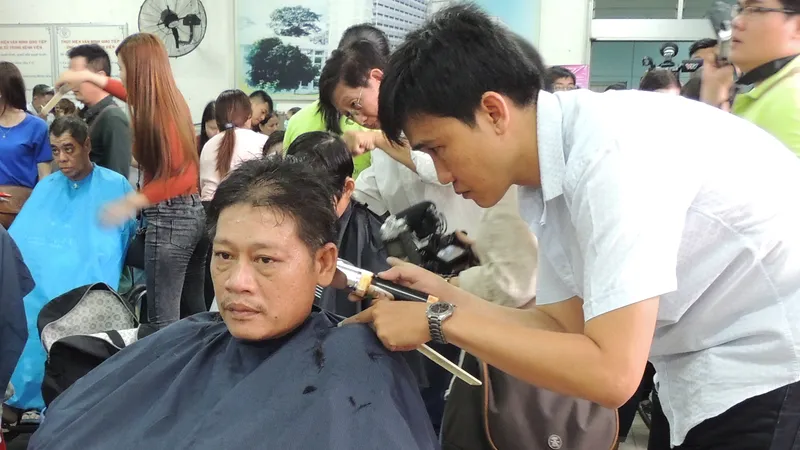 Anh Hàn Văn Thắng được tình nguyện viên cắt tóc. Ảnh: THU HƯỜNG
