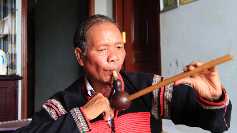  Nghệ nhân Y Wang vừa chơi nhạc cụ truyền thống, vừa hát sử thi Đam San. Ảnh: CÔNG HOAN