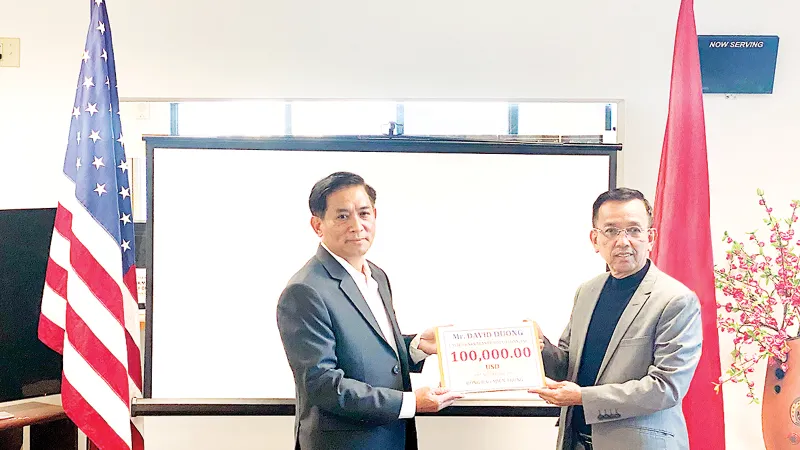 Ông David Dương, Chủ tịch Công ty CWS và VWS (bên phải) trao tặng tiền để hỗ trợ bà con miền Trung đang gặp khó khăn trong mùa bão lũ