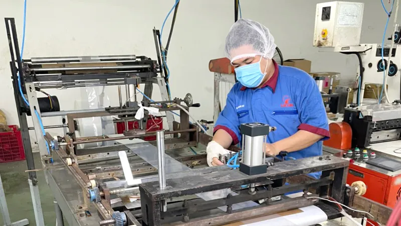 Anh Huỳnh Thanh Vũ, công nhân phân xưởng Cơ điện, Xí nghiệp Bao bì Liksin vận hành sáng kiến cải tiến của mình vào sản xuất. Ảnh: PHƯƠNG UYÊN