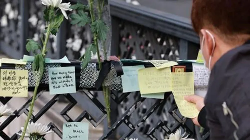 Một người đàn ông đăng thông điệp chia buồn vào ngày 1-11-2022, gần ga Itaewon cho những người thiệt mạng trong vụ giẫm đạp trong lễ hội Halloween tại Itaewon. Ảnh: Yonhap