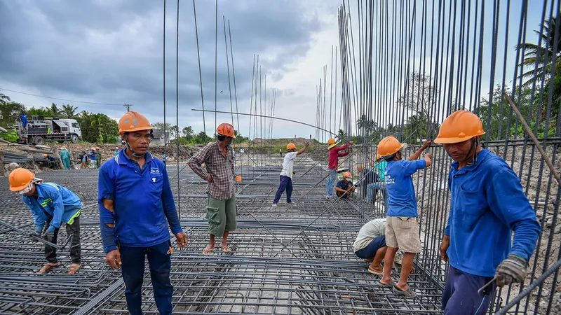 Các công nhân đang thi công đường cao tốc Mỹ Thuận - Cần Thơ. Ảnh: TUẤN QUANG