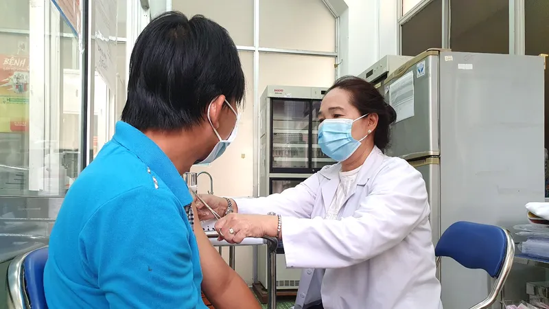 Nhân viên Trung tâm Y tế Quận 8 (TPHCM) tiêm vaccine Covid-19 cho người dân. Ảnh: THÀNH SƠN