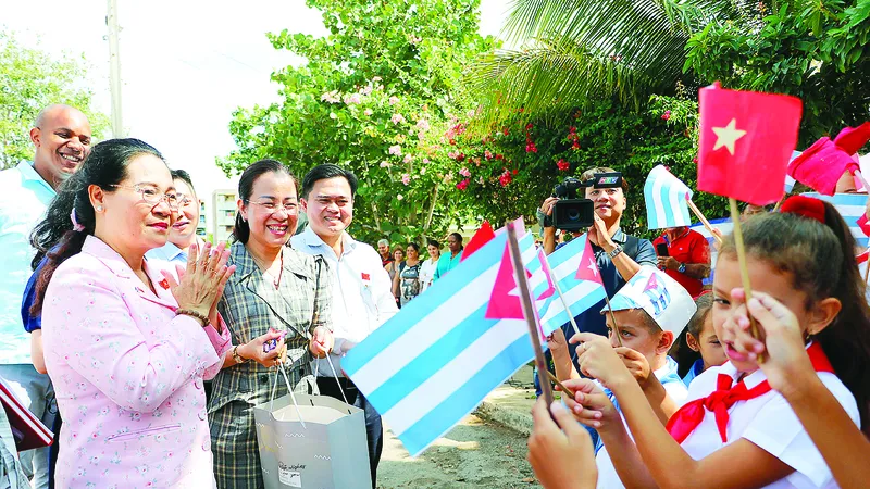 Các em học sinh làng Bến Tre đón đoàn đại biểu TPHCM đến thăm. Ảnh: NGÔ BÌNH 