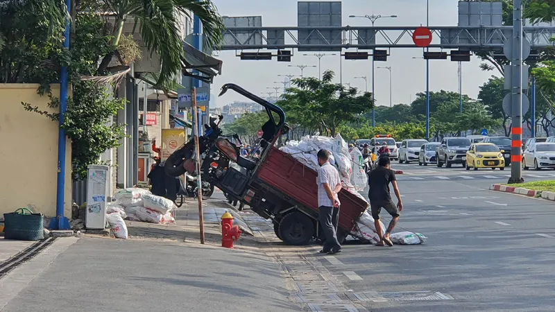  Xe 3 bánh chở vật liệu xây dựng nhổng bánh trên lòng lề đường Võ Văn Kiệt, quận 5, TPHCM