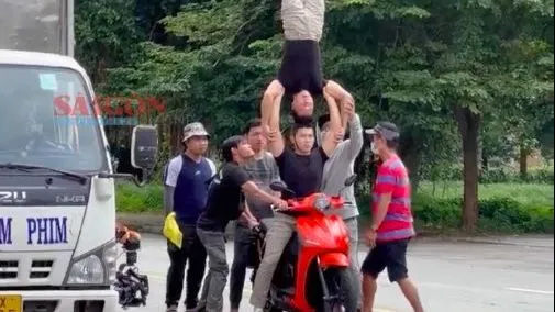 Hình ảnh thực về việc nghệ sĩ Quốc Cơ, Quốc Nghiệp vừa chạy xe vừa làm xiếc chồng đầu.