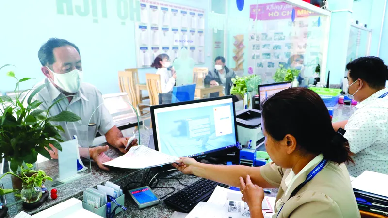 Công chức hộ tịch phường An Phú Đông, quận 12 (TPHCM) giải quyết thủ tục hành chính cho người dân. Ảnh: NGÔ BÌNH