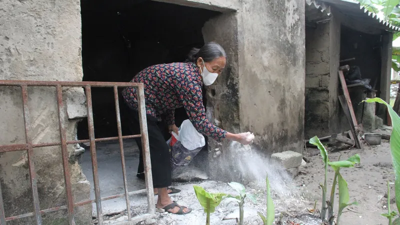 Người dân ở xã Cẩm Dương (huyện Cẩm Xuyên, tỉnh Hà Tĩnh) rải vôi bột phòng chống dịch tả heo châu Phi. Ảnh: DƯƠNG QUANG