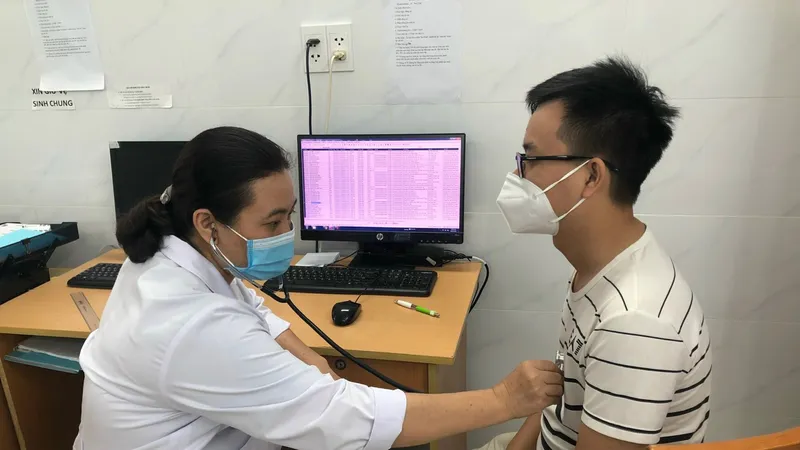 Bác sĩ CKII Trần Thị Vân Anh, Trưởng khoa Nội nhiễm, Bệnh viện Thống Nhất TPHCM thăm khám cho bệnh nhân Ảnh: KIM HUYỀN