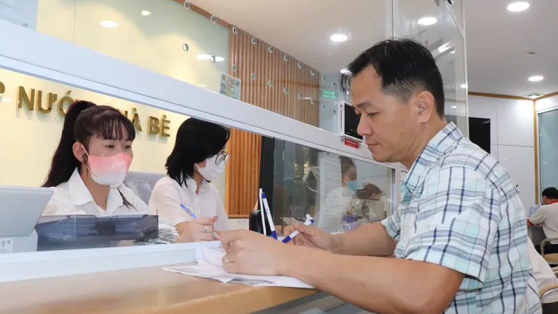 Nhân viên ngành cấp nước TPHCM hướng dẫn người dân đăng ký định mức nước qua ứng dụng VNeID
