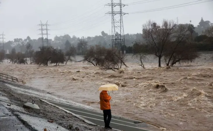 Một người dân chứng kiến lũ lụt nhấm chìm khu vực xung quanh thành phố Los Angeles, ảnh chụp vào ngày 5-2. Ảnh: REUTERS
