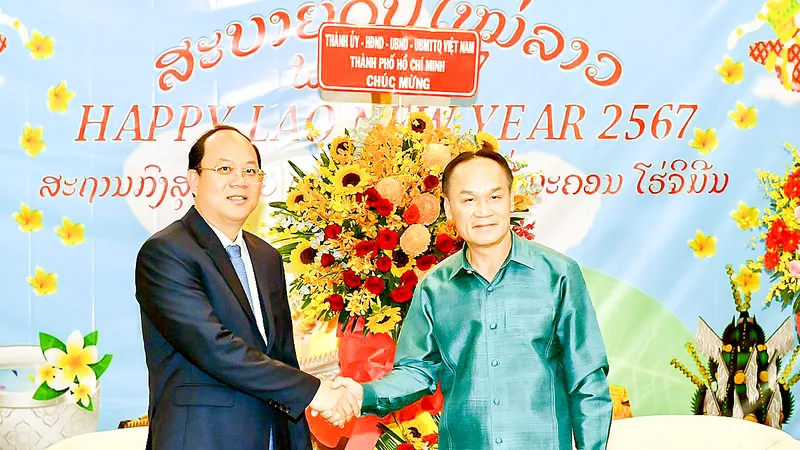 Phó Bí thư Thường trực Thành ủy TPHCM Nguyễn Hồ Hải tặng hoa chúc mừng Tổng Lãnh sự quán Lào tại TPHCM nhân dịp Tết cổ truyền của Lào. Ảnh: VIỆT DŨNG