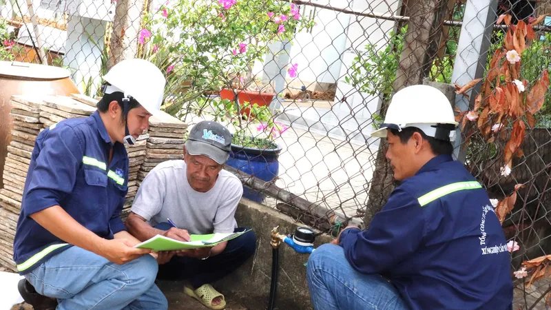 Ông Nguyễn Văn Tới (giữa), ngụ tổ 4, ấp An Hòa, xã Tam Thôn Hiệp (huyện Cần Giờ) ký nhận đồng hồ nước vừa được lắp đặt từ Xí nghiệp Cấp nước Cần Giờ