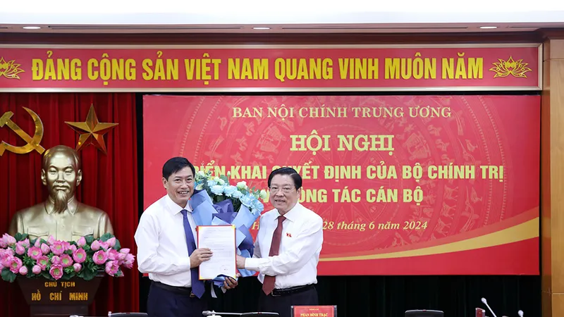 Đồng chí Phan Đình Trạc, Ủy viên Bộ Chính trị, Bí thư Trung ương Đảng, Trưởng Ban Nội chính Trung ương trao Quyết định và tặng hoa chúc mừng đồng chí Nguyễn Hữu Đông. Nguồn: VGP 