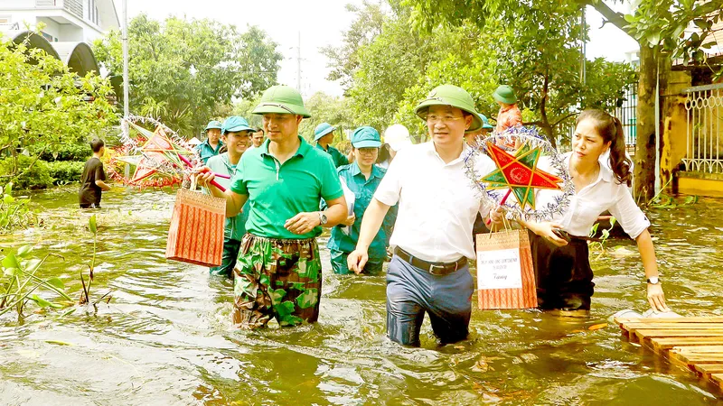 Các nghệ sĩ và các tổ chức, đoàn thể địa phương đến tận nhà những em nhỏ vùng bị ngập lụt ở Hà Nội để trao quà Trung thu. Ảnh: THU HÀ