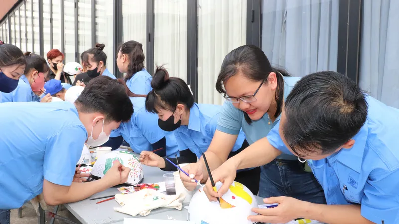 Công nhân Công ty CP Hợp tác Kinh tế và Xuất nhập khẩu Savimex tham gia cuộc thi “Vẽ, trang trí nón bảo hiểm” ngay sân nhà máy