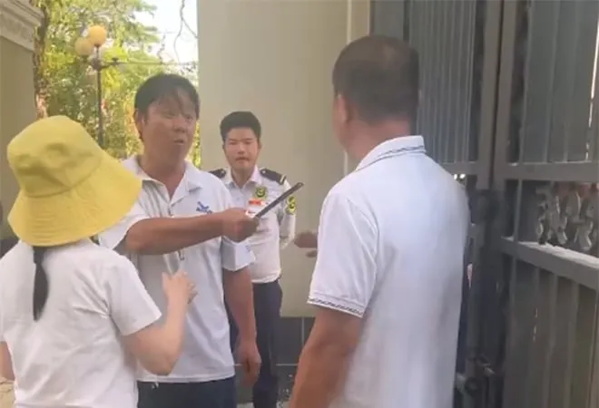 Hình ảnh bà Nguyễn Thị Út Em (người đội mũ màu vàng) cùng một số người đến trước cổng trường vào chiều 26-3